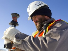 Matt Bell of AGM holds a prism pole as he worked on surveying a construction site in London,on Friday. Bell said this week was "cold," a bit of an understatement, but said Friday was quite nice. (Mike Hensen/The London Free Press)