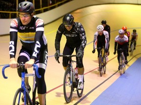 Canadian record cyclist Ed Veal (2nd from left) grimaces as he continues into his 24th hour of cycling at the Forest City Velodrome in London, Ont. on Sunday February 3, 2019.  Veal and the velodrome had hoped to raise $25,000 for new heating and new lighting for the building, which used to be called the London Ice House when it hosted the London Knights. As the 24hr ride finished, a group of last minute pledges raised the amount to $50,000. (Mike Hensen/The London Free Press)