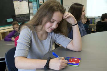 Oana (cct) Tibre, a grade 8 student at Holy Rosary Catholic School, colours a ceramic tile as part of a city wide indigenous reconciliation education project  London. Derek Ruttan/The London Free Press