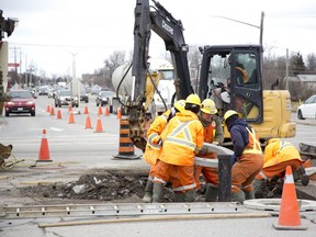 People repair an underground water pipe rupture at the intersection of Wellington Road and Bradley Avenue in London, Ont. on Tuesday. Derek Ruttan/The London Free Press