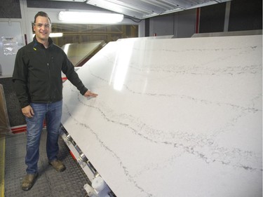 Saul Braga, production manager at HanStone Canada's London manufacturing plant shows a stunning natural quartz surface used in home decor. (Derek Ruttan/The London Free Press)