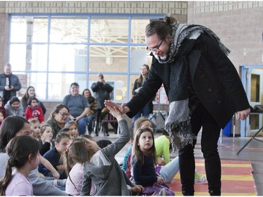 Kevin Drew of the musical group Broken Social Scene greets students at Antler River Elementary School  in Chippewa of the Thames on Friday. He was travelling with Mike and Patrick Downie, brothers of The Tragically Hip's lead singer Gord Downie, as they spoke at school's helping to educate students about the need for reconciliation between Indigenous and non-Indigenous Canadians. Drew co-produced Gord Downie's album called Secret Path, based on the true story of  Chanie Wenjack's escape from a residential school. The 12-year-old perished trying walk 300 kilometres back home.  (Derek Ruttan/The London Free Press)