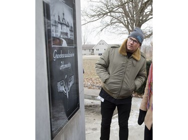Patrick Downie looks at an image of the notorious Mount Elgin Industrial School, an Indian residential school, on a monument honouring its former students in Chippewa of the Thames on Friday February 8, 2019. Patrick's brother Gord Downie, lead singer of The Tragically Hip, created a collection of work about one boy's escape from a different residential school. Chanie Wenjack, 12, perished trying walk 300 kilometres back home. (Derek Ruttan/The London Free Press)