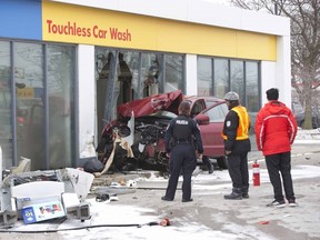 Police speak with the owner of the Shell gas station on the corner of Fanshawe Park and North Centre roads  Sunday Fe. 10,  after a vehicle left the road, knocked over a light standard, drove over a gas pump and crashed into the car wash. The driver, reportedly an elderly woman, was taken to hospital via ambulance. (Derek Ruttan/The London Free Press)