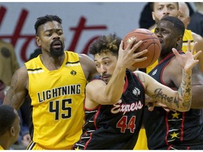 Ryan Anderson of the Windsor Express juggles a rebound in front of the London Lightning's Marvin Phillips in the second half of their NBL game at Budweiser Gardens in London, Ont. on Sunday February 10, 2019.  (Derek Ruttan/The London Free Press)