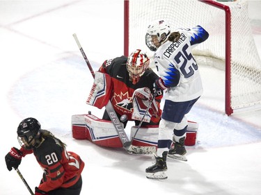 Team Canada goalie Emerance Maschmeyer  stops a point shot while being hounded by Team USA's Alex Carpenter in the first period of their game at Budweiser Gardens in London, Ont. on Tuesday February 12, 2019. (Derek Ruttan/The London Free Press)