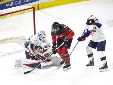 Team USA goalie Alex Rigby stops a point shot while being hounded by Team Canada's Natalie Spooner in the first period of their game at Budweiser Gardens in London, Ont. on Tuesday February 12, 2019. (Derek Ruttan/The London Free Press)