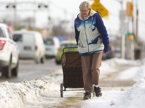 Marie Gilbert of London walks along the now-cleared sidewalks on Dundas Street on Tuesday February 19, 2019.  Gilbert said the sidewalks this weekend were "horrid," and she was unable to walk  unless she went on the street which she didn't want to do. Mike Hensen/The London Free Press/Postmedia Network