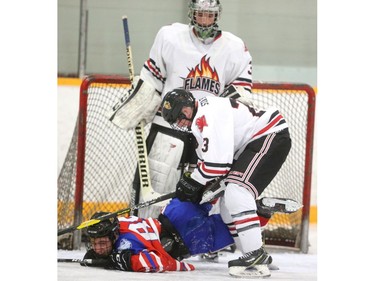 STA's Marcus Hicks goes for a two leg takedown, and just about hogties Bessette's Joey Stimac with a bemused Flames goalie Mike deHenestrossa looking on in the third period of their semifinal game Thursday at Carling arena. The Flames roared to a 6-2 win, forcing a game 3 Friday at Boswick arena. The Bulldogs won the first 4-1. Mike Hensen/The London Free Press/Postmedia Network