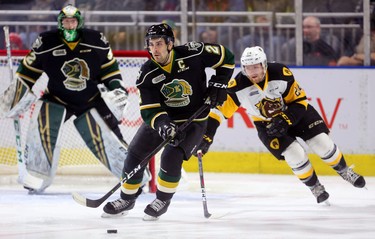 Evan Bouchard of the Knights lugs the puck out of his own end with Hamilton's Liam Stevens in pursuit in the first period of their game at Budweiser Gardens on Friday February 22, 2019.  Mike Hensen/The London Free Press/Postmedia Network