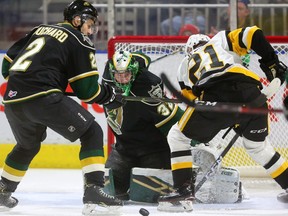 Joseph Raaymakers of the London Knights keeps his eyes on the puck as Jan Jenik of the Hamilton Bulldogs digs for the rebound being checked by Evan Bouchard of the Knights in the first period of their game at Budweiser Gardens on Friday, Feb. 22, 2019. (Mike Hensen/The London Free Press)