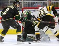 Joseph Raaymakers of the London Knights keeps his eyes on the puck as Jan Jenik of the Hamilton Bulldogs digs for the rebound being checked by Evan Bouchard of the Knights in the first period of their game at Budweiser Gardens on Friday, Feb. 22, 2019. (Mike Hensen/The London Free Press)