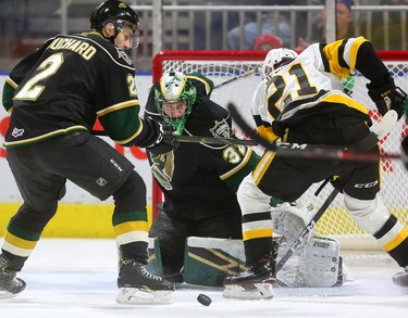 Joseph Raaymakers of the Knights keeps his eyes on the puck as Jan Jenik of the Hamilton Bulldogs digs for the rebound being checked by Evan Bouchard of the Knights in the first period of their game at Budweiser Gardens on Friday February 22, 2019.  Mike Hensen/The London Free Press/Postmedia Network
