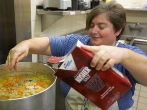 Darlene Zaifman, the volunteer co-ordinator for the Jewish Community Centre's 13th annual Come In From Out Of The Cold, adds a touch of salt to her "Jewish penicillin," a large vat of chicken soup that will be part of a warm lunch being held Sunday for over 300 people who will be bused to the the Centre from locations downtown and in east London.  Mike Hensen/The London Free Press