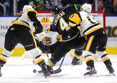 William Lochead of the Knights tries to bull his way to Hamilton goalkeeper Zachary Roy but cant get through the combined check of Kade Landry and Avery Hayes of the Bulldogs in the first period of their game at Budweiser Gardens on Friday February 22, 2019.  Mike Hensen/The London Free Press/Postmedia Network