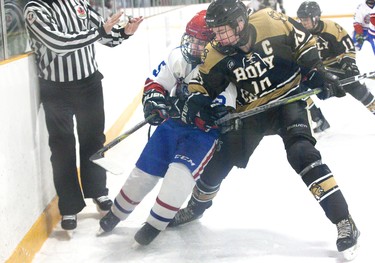 Holy Cross Centurion  captain Blake Griffiths checks Saint Andre Bessette Bulldog Keegan Mitchell at Nichols Arena  in London, Ont. on Tuesday. The Bulldogs won the game 4-2 and the TVRA AA London District championship series two games to none. Derek Ruttan/The London Free Press/Postmedia Network