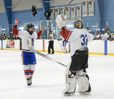 Saint Andre Bessette Bulldogs Will Ryan and  goalie Gordie O'Dwyer celebrate after defeating the Holy Cross Centurions 4-2 to win the TVRA AA London District championship series two games to none at Nichols Arena in London, Ont. on Tuesday .  Derek Ruttan/The London Free Press/Postmedia Network