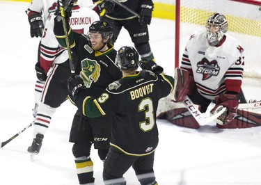 London Knight Kevin Hancock and Adam Boqvist celebrate in front  Guelph Storm goalie Anthony Popovich after Hancock swung his stick like a baseball bat and swatted the puck out of the air and into the net during the first period of their game in London, Ont. on Tuesday. Derek Ruttan/The London Free Press/Postmedia Network