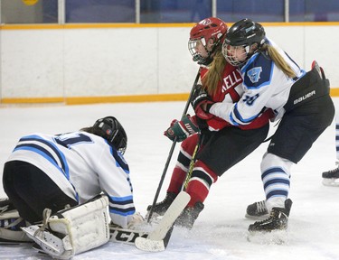 Lucas Viking Cierra Troyer steers Medway Cowboy Claire Kelly away from goalie Maddie Casson during their game at Carling Arena in London, Ont. on Wednesday. Medway won the game 6-1 to take the series 2-0 and win the TVRA Central hockey championship.Derek Ruttan/The London Free Press/Postmedia Network