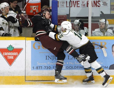 Peterborough Petes' Austin Osmanski, left, is checked along the boards by London Knights' Cole Tymkin during first period OHL action on Thursday, Feb. 21, 2019 at the Memorial Centre in Peterborough. (Clifford Skarstedt, Peterborough Examiner)