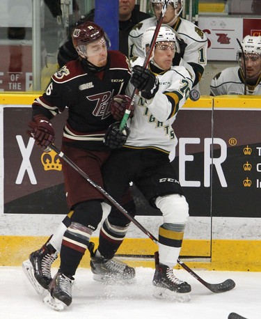 Peterborough Petes' Austin Osmanski, left, collides with London Knights' Matvey Guskov during first period OHL action on Thursday, Feb. 21, 2019 at the Memorial Centre in Peterborough. (Clifford Skarstedt, Peterborough Examiner)