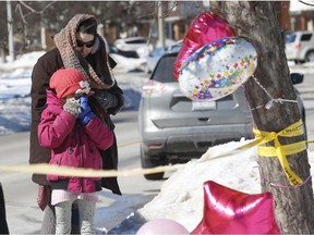 A mourning mother consoles her daughter after they dropped off flowers and a birthday balloon to a home where the body of 11-year-old Riya Rajkumar was found last Thursday. (Toronto Sun)