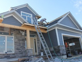 Jacob Dyck of Dyck Exterior Installation works on the roof of a house being built in Mt. Brydges. Dyck says he's worked on about 30 houses within the same subdivision over the last year or so. (JONATHAN JUHA, The London Free Press)