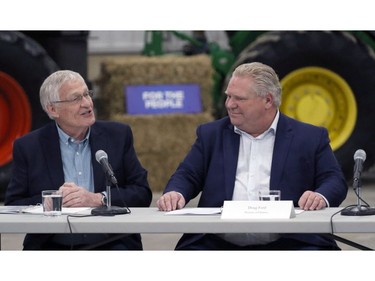 Minister of Agriculture, Food and Rural Affairs Ernie Hardeman, left, and Ontario Premier Doug Ford talk before a roundtable with local farmers at Veldale Farms Ltd. south of Woodstock on Thursday. (Greg Colgan/Postmedia Network)