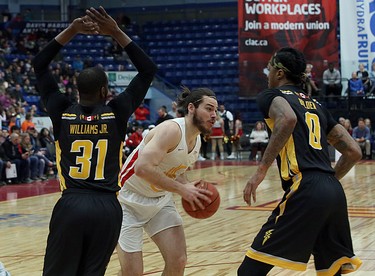 Devin Gilligan of the Sudbury Five looks to make a pass while under pressure from Kirk Williams Jr. and Mo Bolden of the London Lightning during first-half National Basketball League of Canada action at Sudbury Community Arena in Sudbury on Sunday.  (Ben Leeson/Postmedia Network)