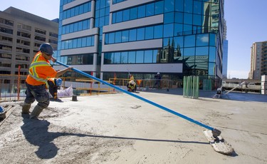 Jim Cordeiro of Ellis Don smooths out freshly poured concrete on the third floor of the new Old Oak tower at the corner of Richmond Street and Dufferin Avenue in London, Ont.  It was a perfect day for pouring concrete at the new tower, which will house 175 apartments. Photograph taken on Tuesday March 19, 2019.  Mike Hensen/The London Free Press/Postmedia Network