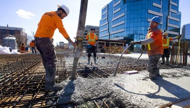 Ricardo Cordeiro of Ellis Don pours out concrete as Nick De Sousa eliminates air pockets and bubbles on the third floor of the new Old Oak tower rising at the intersection of Richmond Street and Dufferin Avenue in London, Ont. It was a perfect day for pouring concrete at the new tower, which will house 175 apartments. Photograph taken on Tuesday March 19, 2019.  Mike Hensen/The London Free Press/Postmedia Network