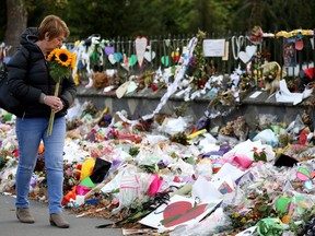 A woman walks past flowers and tributes displayed in memory of the twin mosque massacre victims at the Botanical Garden in Christchurch on March 29, 2019. - The remembrance ceremony is being held in memory of the 50 lives that were lost in the March 15th mosque shootings in Christchurch. (Photo by Sanka VIDANAGAMA / AFP)SANKA VIDANAGAMA/AFP/Getty Images