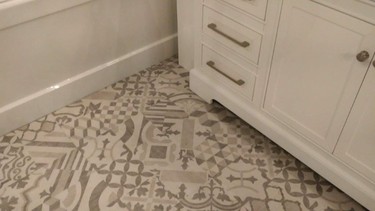 Vinyl plank flooring that replicates porcelain tile, shown with a furniture-style vanity.