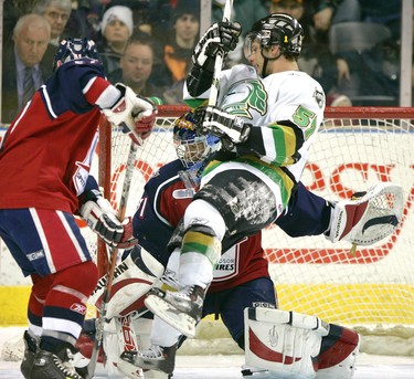 Knights forward Jordan Foreman gets knocked off his feet by Windsor's Mark Cundari while Foreman was trying to screen Spitfires goalie Matt Hackett in the first period of their game Friday night at the John Labatt Centre in London (2007).