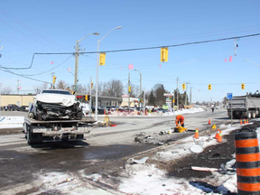 Crews work to remove a vehicle and damaged light pole following a collision at the intersection of Campbell and Main streets in Lambeth Friday morning that sent two people to hospital. JONATHAN JUHA/THE LONDON FREE PRESS