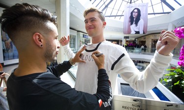 Joe Depace, a London native, uses his partner Andrew Fedyk as a desk to write the name of their band, Loud Luxury, on a fan's T-shirt at the Juno Fan Fare at Masonville Place mall in London, Ont. Long lines of fans were on hand to be photographed with nominees such as Loud Luxury, Killy, the Reklaws and The Washboard Union.
Photograph taken on Saturday March 16, 2019. Mike Hensen/The London Free Press/Postmedia Network