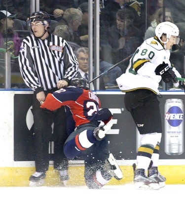 Cole Carter of the Windsor Spitfires crashes into a linesman after bouncing off London Knight Alex Forementon during the first period of their OHL hockey game at Budweiser Gardens in London, Ont. on Sunday November 20, 2016. Derek Ruttan/The London Free Press/Postmedia Network