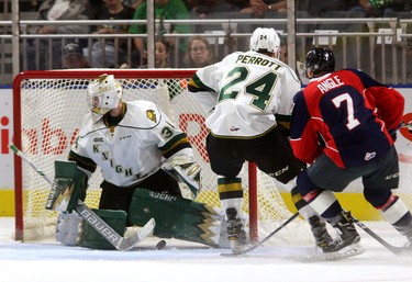Knights goaltender Tyler Johnson looks for the puck that's beneath his pads while Knights defenceman Andrew Perrott keeps Tyler Angle of the Spitfires away from the net during the first period of their game at Budweiser Gardens on Friday September 22, 2017. At the end of the first the game was tied up at 1-1. Mike Hensen/The London Free Press/Postmedia Network