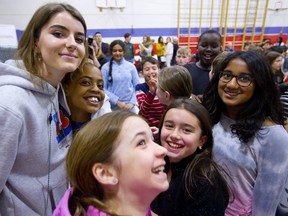 bülow, a young artist nominated for four Junos gives a quick hug to Emmanuella Temperman, 10 while being surrounded by students at St. Paul Catholic elementary school during an assembly on Monday.  bülow was part of a Musicounts announcement that $15,000 worth of musical instruments were being given to the school. The money was raised by the London Juno organizing committee who added $1 to each ticket to raise funds for the organization which tries to keep music alive in London schools. (Mike Hensen/The London Free Press)