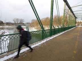 Leila Russell walks across the King Street pedestrian bridge just south of the fork of the Thames earlier this month.  The future of the Back to the River project is up for debate at city council next week. (MIKE HENSEN, The London Free Press)