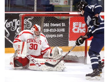 Medway's Quinton Duncan makes a save with CCH's Jamison McGann sweeping in for a rebound during their WOSSAA AAA gold medal game at Joe Thornton Community Centre in St. Thomas on Tuesday March 5, 2019.  The Cowboys rode their shut-out goalie to a 2-0 win for the gold and will move on to OFSAA in Barrie. Mike Hensen/The London Free Press/Postmedia Network