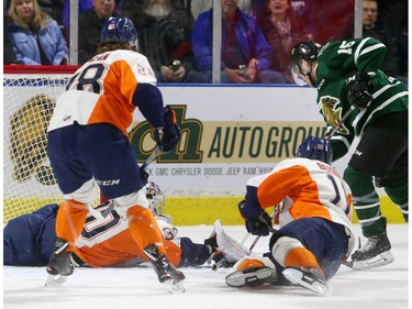 Cole Tymkin fights for control of the puck off the side of the Flint net with Emanuel Vella of the Firebirds already down and Dennis Bushby of Flint diving to knock the puck away and Vladislav Kolyachonok tries to get in on the play during the first period at Budweiser Gardens Friday. (MIKE HENSEN, The London Free Press)