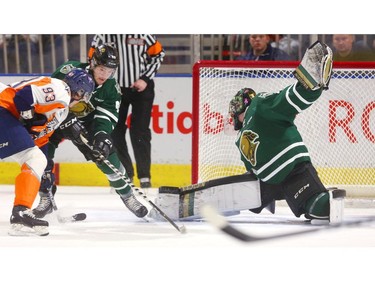 London goalie Jordan Kooy thrusts his pad out as Knights forward Paul Cotter ties up Hunter Holmes of the Flint Firebirds during the first period of their OHL game at Budweiser Gardens on Friday night. The Knights won 3-2 in overtime on Adam Boqvist's breakaway goal. (MIKE HENSEN, The London Free Press)