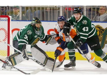 Jordan Kooy watches the puck get away from Ethan Keppen of the Flint Firebirds as Keppen is checked by Paul Cotter during the first period at Budweiser Gardens Friday. Keppen scored the only goal of the first period. (MIKE HENSEN, The London Free Press)
