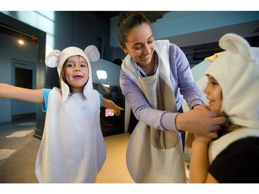 Alicia Wright finishes buttoning the costume on Rhiana Parada while her daughter, Sophia Baljet, happily models her polar bear outfit at the London Children's Museum pajama party held on Friday. The museum has a full slate of activities to help parents out during March break. (Mike Hensen/The London Free Press)
