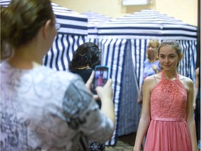 Melissa Houghton, 13, of Norfolk County, tries on one of about 2,000 donated prom dress while her mom, Annie, sends a photo to an older sister for approval during Cinderella Project fittings at London’s Four Points Sheraton hotel Tuesday. (MIKE HENSEN, The London Free Press)