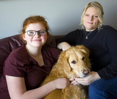 Olivia Vander Schelde, her pooch Cooper and her mom Kim Hunter Vander Schelde who is making a human rights complaint that children's cancer funding is at 5% compared to adults in Canada.  Her daughter had cancer as an infant. (Mike Hensen/The London Free Press)