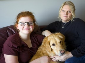 Olivia Vander Schelde, her pooch Cooper and her mom Kim Hunter Vander Schelde who is making a human rights complaint that children's cancer funding is at 5% compared to adults in Canada.  Her daughter had cancer as an infant. (Mike Hensen/The London Free Press)