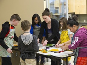 Meagan Warwick supervises a group of 11-year-olds in the Let's Get Cooking program at the Fanshawe Family Centre in London on Thursday. Let's Get Cooking is a program offered by LUSO Community Services, one of the agencies that will have 10 per cent of its United Way Elgin Middlesex funding cut. Learning kitchen skills and safety are Kevin Constantine, left, Zack Smith, Nyvein Ongcuangco, Alyssa Vanbesien and Ismirti Mongar. (Derek Ruttan/The London Free Press)