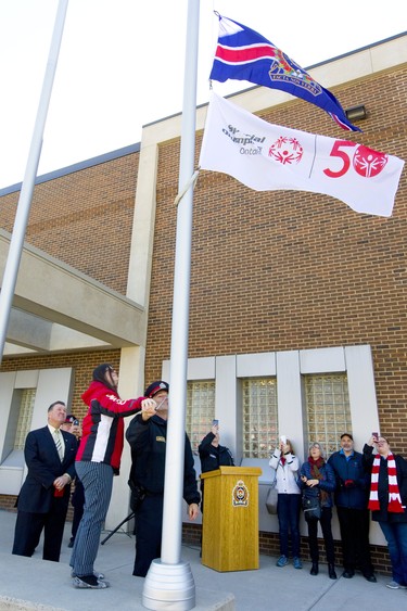 London police get start to raise the 50th anniversary flag for the Special Olympics outside their headquarters on Monday March 25, 2019. Special Olympian Valerie Nyhout, who won the silver medal in downhill skiing at the Special Olympics in Austria 2017, helped to raise the flag along with deputy chief Daryl Longworth. Mike Hensen/The London Free Press/Postmedia Network
